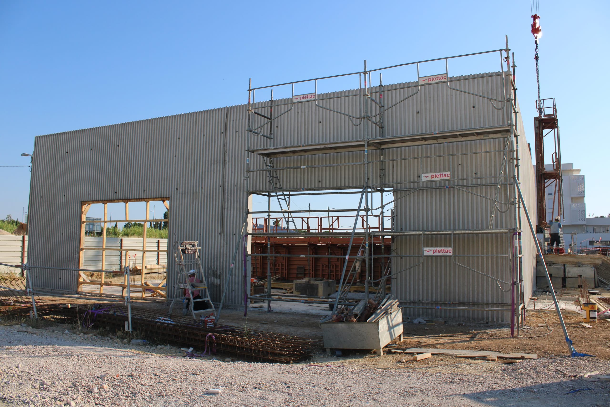 Voile en béton banché sous échafaudage, percé de deux baies, sur le chantier de la Résidence Le Phanios