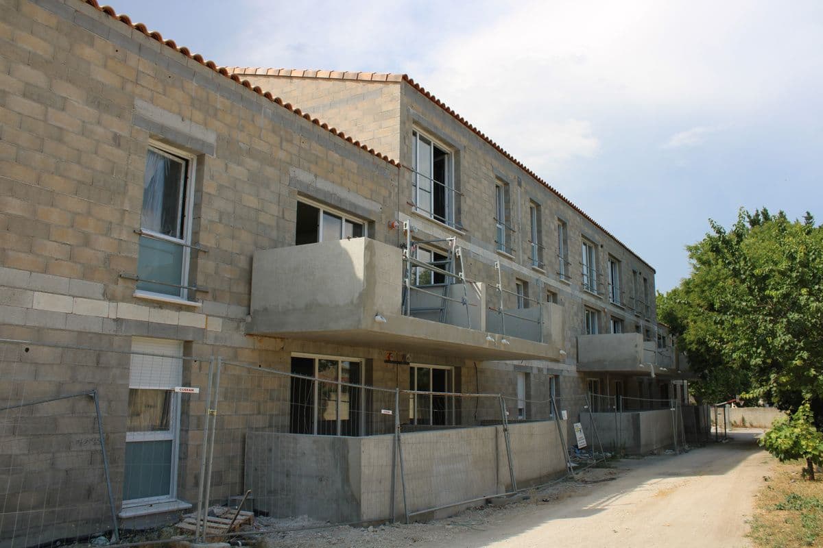 Façade en blocs béton, balcons en béton brut et menuiseries posées