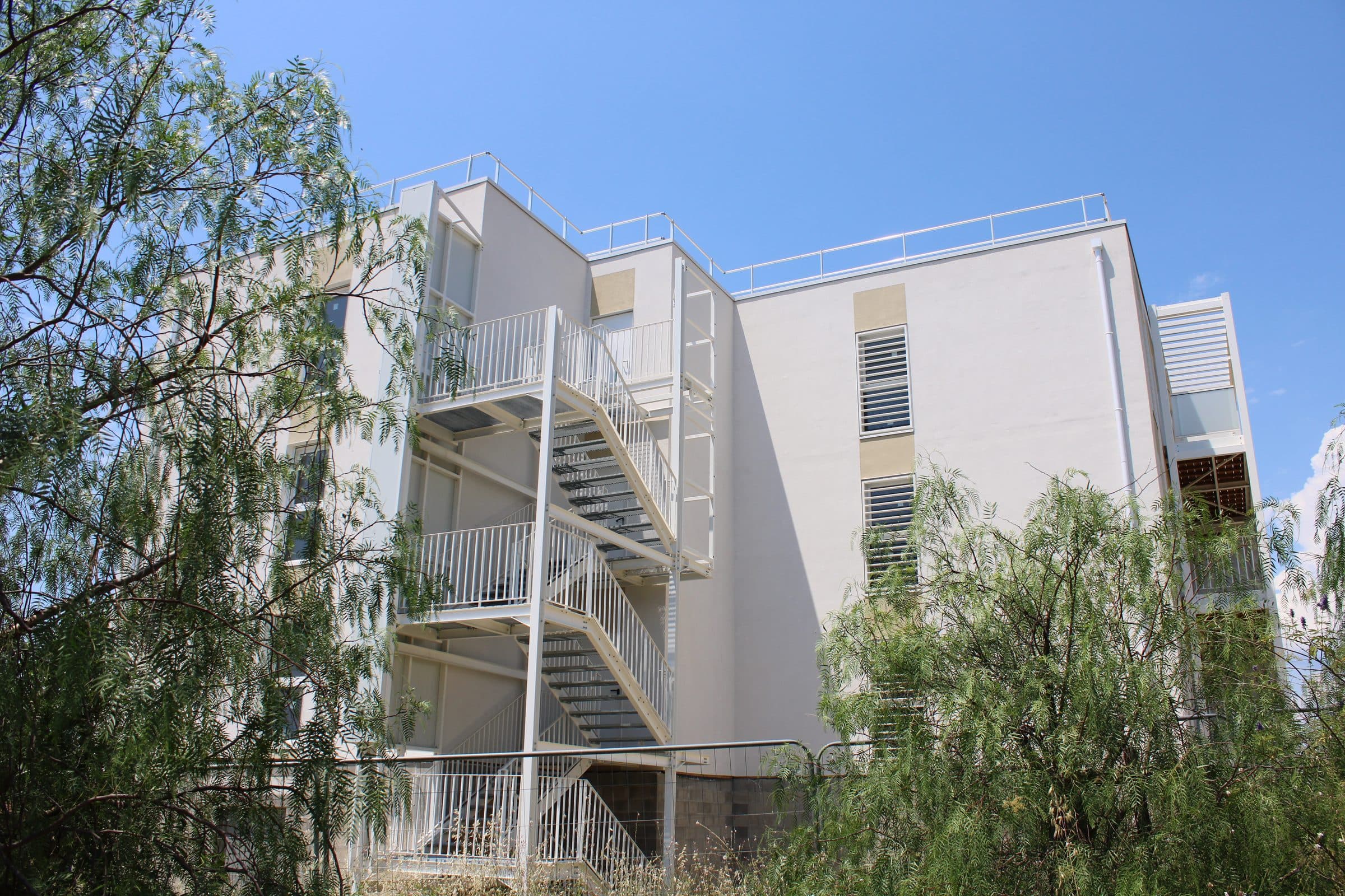 L’escalier extérieur métallique de la résidence, entre les arbres